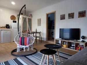 a living room with a chair and a tv at Casa25 in Alenquer