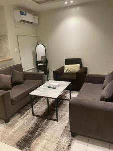 een woonkamer met een bank en een salontafel bij دار داكن للشقق المخدومة in Riyad