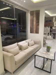 Una sala de estar con un sofá blanco y una mesa. en دار داكن للشقق المخدومة اقتصادي, en Riad