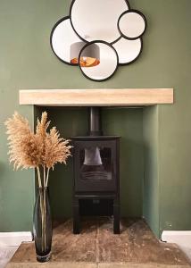a mirror above a fireplace with a vase with flowers at 4@No.4. A cosy spot for 4 and one furry friend in Cawood