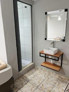 a bathroom with a sink and a mirror at Pousada Aviação in Praia Grande