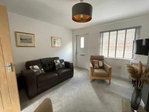 a living room with a couch and a chair at 4@No.4. A cosy spot for 4 and one furry friend in Cawood