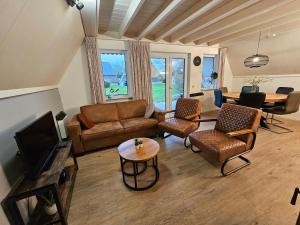 een woonkamer met een bank en een tafel bij 6 pers. vakantiehuis aan visvijver op vakantiepark, Time4vacay in Gramsbergen