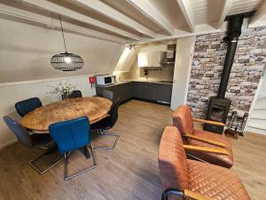 een kamer met een tafel en stoelen en een keuken bij 6 pers. vakantiehuis aan visvijver op vakantiepark, Time4vacay in Gramsbergen