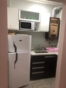 a kitchen with a white refrigerator and a microwave at Mar del plata in Mar del Plata