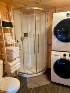 a bathroom with a shower and a washing machine at Le POD'Stress / Nature et tranquilité in Saint-Alexis-des-Monts