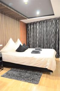 - une chambre avec un grand lit blanc et un tapis dans l'établissement Apartments Am Werdersee, à Brême