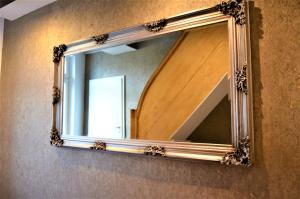 a mirror with a wooden frame on a wall at Apartments Am Werdersee in Bremen