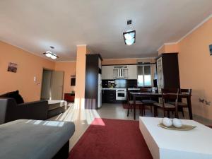 ein Wohnzimmer und eine Küche mit einem Sofa und einem Tisch in der Unterkunft Elbasan center family apartment n.42 in Elbasan