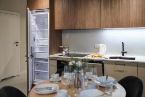 uma cozinha com uma mesa com cadeiras e um frigorífico aberto em Lucky Seven em Poznań