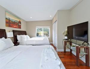 a bedroom with two beds and a flat screen tv at Mid-Century Seattle Home w/ Lakefront Views! in Seattle
