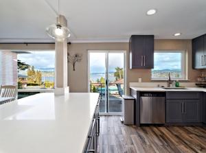a kitchen with white countertops and a large window at Mid-Century Seattle Home w/ Lakefront Views! in Seattle