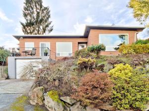 a house on a hill with plants at Mid-Century Seattle Home w/ Lakefront Views! in Seattle