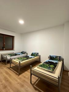 three beds in a room with wooden floors at Duisburg FeelHome, Flughafen nah, 6 Personen, Badewanne, Zentral, WiFi, Ground Floor in Duisburg
