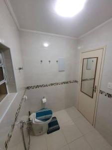 a bathroom with a toilet with a blue seat at Apto completo - Solemar/PG in Praia Grande