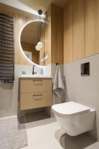 Un baño con inodoro, lavabo y espejo. en Lucky Seven, en Poznan 56 fotos más