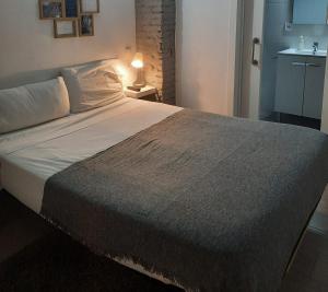 a large bed in a bedroom with a lamp on a table at Bonito Alojamiento F in Valencia