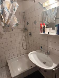 een witte badkamer met een wastafel en een douche bij Schwarzwald Zauberhütte in Löffingen