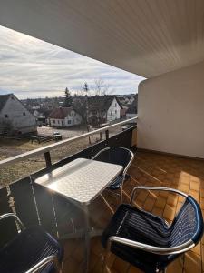 een patio met een tafel en stoelen op een balkon bij Schwarzwald Zauberhütte in Löffingen