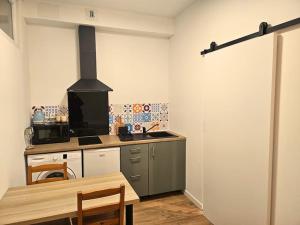 een keuken met een fornuis en een tafel. bij NERO studio confort tt équipé! in Villejuif