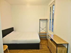 1 dormitorio con 1 cama, vestidor y ventana en NERO studio confort tt équipé!, en Villejuif