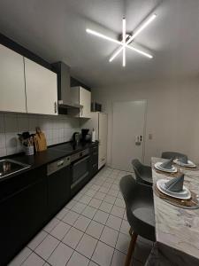 a kitchen with black cabinets and a ceiling fan at Ferienwohnung 24 Unten Rechts 3 Zimmer in Lathen