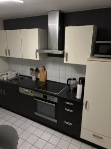 a kitchen with black counters and a white refrigerator at Ferienwohnung 24 Unten Rechts 3 Zimmer in Lathen