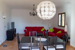 a living room with a red couch and a table at Chalet Font de Sa Cala in Font de Sa Cala