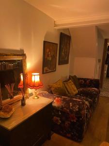 a living room with a couch and a table with a lamp at Boutique Townhouse in Christchurch