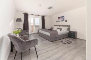 1 dormitorio con 1 cama y 1 silla en Deluxe Apartments 55, en Rateče