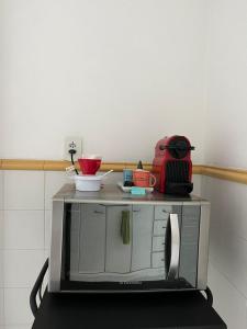 a microwave with bowls and plates on top of it at Apartamento Aconchegante na Zona Sul, Botafogo Rj in Rio de Janeiro