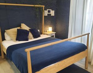 a bedroom with a wooden bed with a blue blanket at Bonito Alojamiento F in Valencia