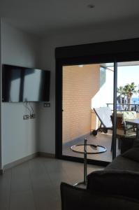 a living room with a flat screen tv on the wall at Albir Beach & Sea Apt in Albir