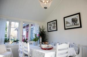 a dining room with a table with white chairs and an elephant at Grandma's cottage in Tanum