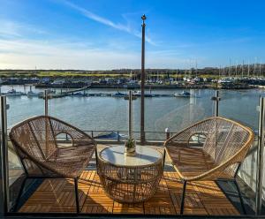 two chairs and a table on a balcony with a marina at River View Luxury Apartment in Littlehampton