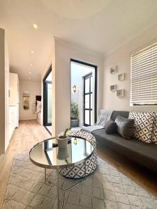 a living room with a couch and a glass table at The Saasveld in Cape Town +6 photos