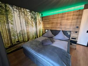 ein Schlafzimmer mit einem großen Bett mit einer Holzwand in der Unterkunft woidpanorama Ferienwohnungen in Neuschönau
