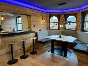 a kitchen with a table and stools in a room at woidpanorama Ferienwohnungen in Neuschönau