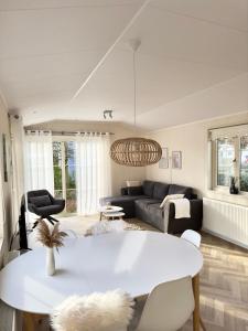 een woonkamer met een witte tafel en een bank bij Chalet Sirun Strandcamping Valkenisse, Biggekerke in Biggekerke