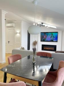 奇西瑙的住宿－Elegant and cosy apartment，客厅配有桌椅和电视。