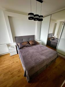 1 dormitorio con cama y espejo grande en Jurajska Plaza - Nowoczesny apartament z osobną sypialnią, Parking GRATIS - HK Apartaments Kielce en Kielce
