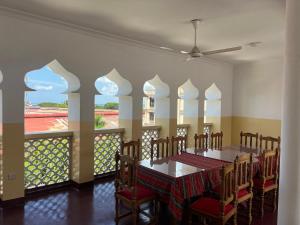 a dining room with a table and chairs and a balcony at Bin Omar Malindi Apartment in Stone Town