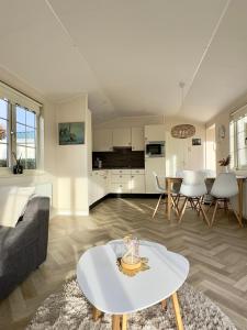 een woonkamer met een bank en een tafel bij Chalet Sirun Strandcamping Valkenisse, Biggekerke in Biggekerke