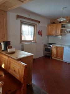 eine Küche mit Holzschränken und einem Herd mit Backofen in der Unterkunft Chalet Shalom in Livigno