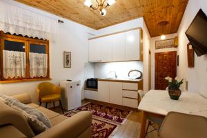 uma cozinha e sala de estar com um sofá e uma mesa em A&Fabio Guesthouse em Gjirokastër