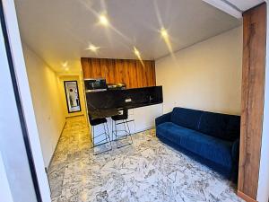 a living room with a blue couch and a piano at Côte d'Azur Oasis Suites in Nice