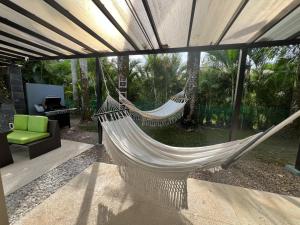 a patio with two hammocks and a green chair at Casa de campo Villavicencio in Villavicencio