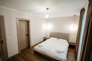a bedroom with a white bed with two pillows at Cabana A-Frame NorthLand in Borşa