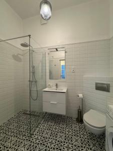 a bathroom with a shower and a sink and a toilet at Nowogrodzka 6a 23 in Warsaw