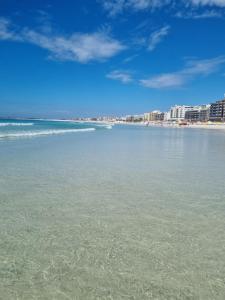 Blick auf einen Strand mit Gebäuden und das Meer in der Unterkunft Apto luxo de 2 quartos, 3 banheiros Praia do forte in Cabo Frio